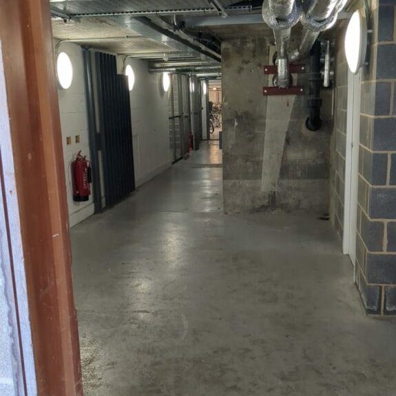 The basement corridor, turning left at the foot of the stairs